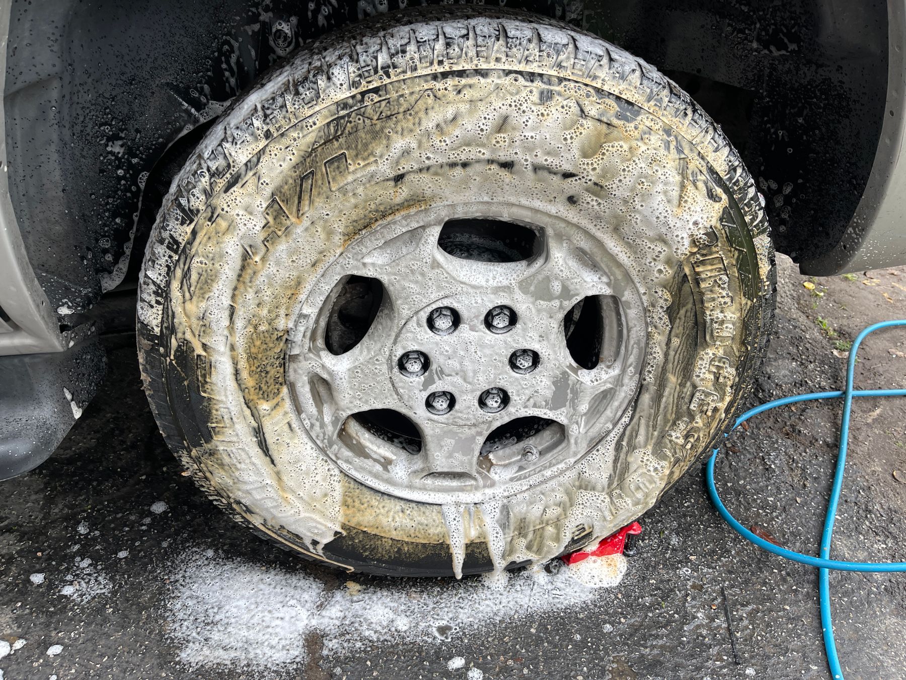Vehicle wheel covered in cleaning foam